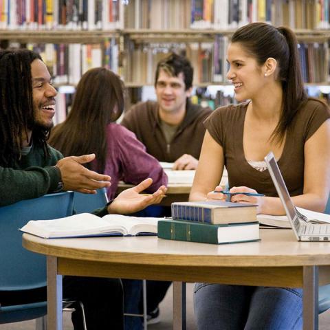 Students work at a table in the library